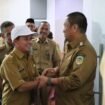 Bupati Luwu Timur, Irwan Bachri Syam berjabat tangan dengan PJ Kades yang baru dilantik beberapa waktu lalu. (Ist)