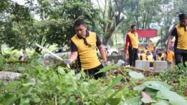 Kapolres Lutim AKBP Zulkarnain membabat rumput liar di TPU, Kelurahan Malili, Jumat (20/06/25). 