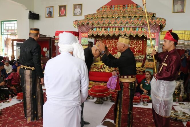 
					Datu Luwu Ke 40, Andi Maradang Mackulau Opu To Bau (kanan,) memasangkan songkok recca kepada Andi Hatta Marakarma di istana Kedatuan Luwu, Palopo, Senin, (06/07/25). 