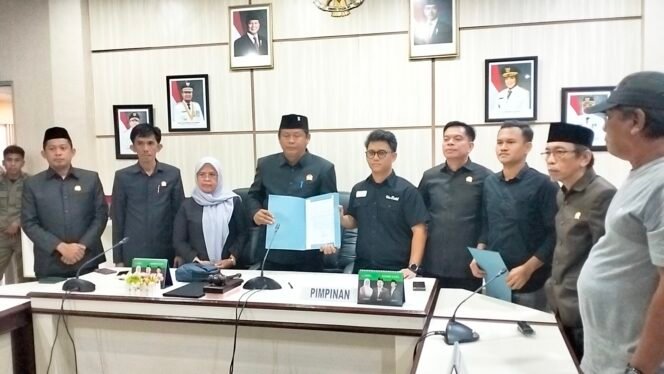 
					Achmad Mujaddid Siddiq (pakai kaca mata) menyerahkan surat gugatan ke Ketua DPRD Lutim Ober Datte (pegang map) Jum'at, (11/07/25)