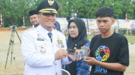 Bupati Luwu Timur Irwan Bachri Syam memberikan kartu pintar pada HUT Ke-80 Kemerdekaan Republik Indonesia, Minggu (17/08/25). 