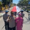 Kapolres Barru, AKBP Ananda Fauzi Harahap bersama Istrinya Rina Ananda ikut membentangkan bendera merah putih sepanjang 800 meter.