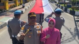 Kapolres Barru, AKBP Ananda Fauzi Harahap bersama Istrinya Rina Ananda ikut membentangkan bendera merah putih sepanjang 800 meter.