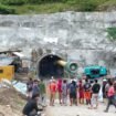 Petugas Kepolisian bersama pekerja berusaha mengevakuasi pekerja yang terjebak di dalam terowongan. 