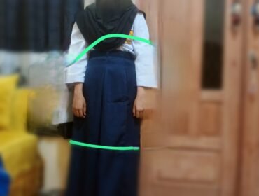 Seorang siswa mencoba baju seragam sekolah gratis yang dibagikan. Sudah kekecilan, Selasa, (31/03/2026)