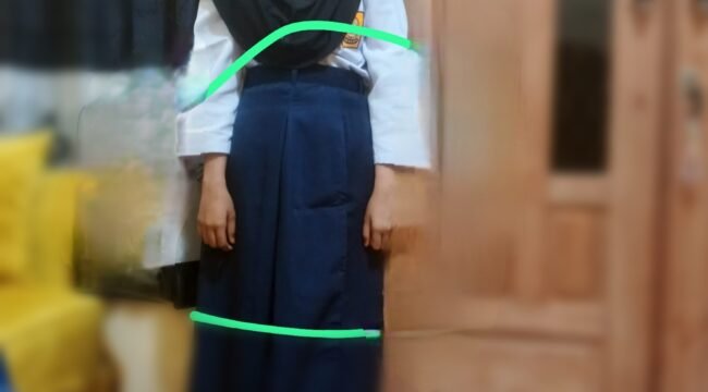 Seorang siswa mencoba baju seragam sekolah gratis yang dibagikan. Sudah kekecilan, Selasa, (31/03/2026)